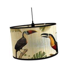 a lamp shade with toucan birds and palm leaves on the bottom, hanging from a black cord