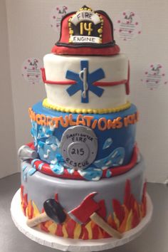 a multi layer cake decorated with fire and rescue symbols