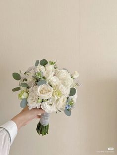 a person holding a bouquet of white flowers