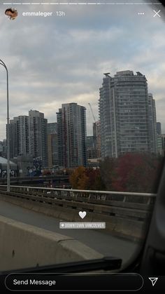 an image of a train going down the tracks in front of some tall buildings on a cloudy day