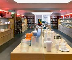 a room filled with lots of glass vases and bowls on top of wooden tables