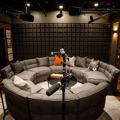 a large gray couch sitting in front of a microphone