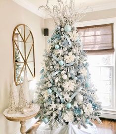 a decorated christmas tree with blue and white ornaments