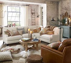 a living room filled with lots of furniture next to a brick wall covered in windows