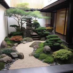 a japanese garden with rocks, grass and trees on the ground in front of a building