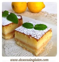 two pieces of cake with powdered sugar on top and lemons in the background