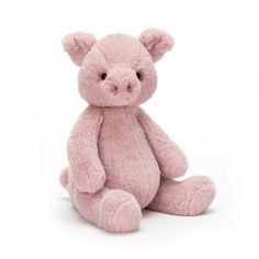 a pink teddy bear sitting on the ground with it's head turned to the side