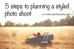 a small toy airplane sitting in the middle of a field with two people on it