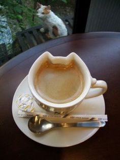 a cup of coffee on a saucer with spoons