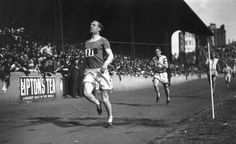 two men running on a field in front of a crowd