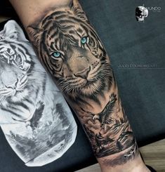 a tiger with blue eyes is on the arm and behind it is a white tiger