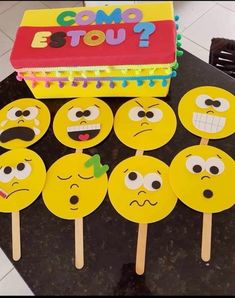 a table topped with lots of yellow cupcakes covered in googly eyes and faces