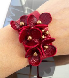 a close up of a person's arm wearing a bracelet with flowers on it