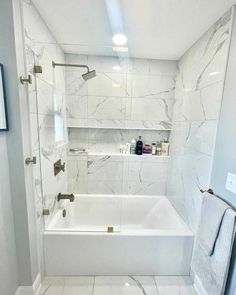 a white bathroom with marble flooring and bathtub in the corner, along with shelving on the wall