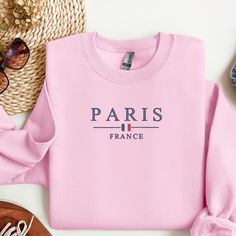 Embrace the charm of Paris with our Minimalistic Paris France Embroidered Crewneck. Perfect for Paris enthusiasts and fashion-forward individuals, this unisex crewneck offers a stylish yet understated way to show your love for the City of Light. Features: Design: Center chest embroidery featuring "Paris France" with a mini French flag accent Material: Soft and durable 50/50 cotton-polyester blend for maximum comfort and longevity Sizes: Available in unisex sizes S, M, L, XL, and 2XL Colors: Choo Trendy Crew Neck Sweater With Letter Embroidery, Paris Sweatshirt, French Flag, Visit Paris, Embroidered Crewneck, Pink Sports, Design Center, 50 50, Minimalist Fashion