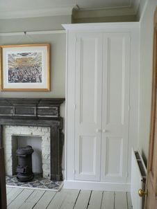 an empty room with a fireplace and pictures on the wall