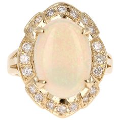 Stunning Opal and Diamond Ring made in a 14K Yellow Gold setting and weighs approx. 8.2 grams. The Oval Cut Opal in this ring weighs 3.65 carats and the measurements of the Opal are 11mm x 15mm. The Opal is surrounded by 20 Round Cut Diamonds that weigh 0.56 carats. The total carat weight of this ring is 4.21 cts. The ring is a size 7 and can be re-sized if needed at no additional cost. Diamond Cluster Rings, Opal And Diamond Ring, Opal Diamond Ring, Yellow Diamond Rings, Yellow Gold Diamond Ring, Opal Ring Gold, Gold Statement Ring, Cluster Rings, Gold Art Deco