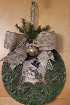 a christmas ornament with a snowman on it hanging from a wooden wall