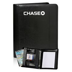 a black leather folder with the word chase on it and magazines in front of it