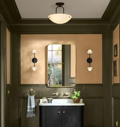 a bathroom with a sink, mirror and lights on the wall next to an open door