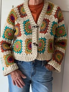 an older woman wearing a crocheted jacket and jeans