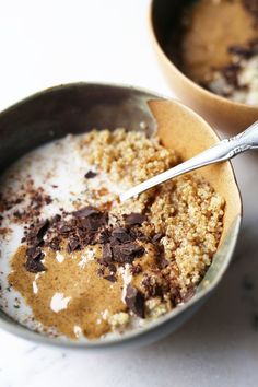 two bowls filled with cereal and chocolate crumbs on top of a white table