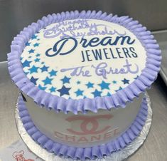 a purple and white cake with the words dream jewelers on it's side