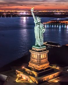 the statue of liberty is lit up at night