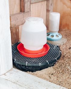 a plastic jug sitting on top of a metal grate in front of a door