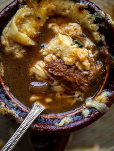 a close up of a bowl of food on a table with a spoon in it