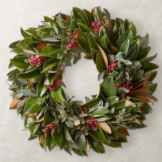 a christmas wreath with red berries and green leaves on a white background, ready to be hung