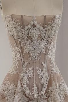 the back of a wedding dress with white flowers on it and lace overlays