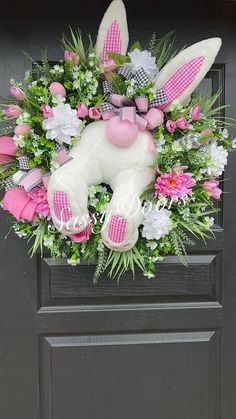 a pink and white bunny wreath on a door