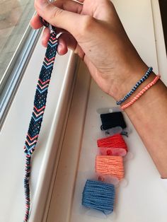 a person is holding an item in their hand near other items on the window sill