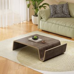 a living room with a couch, coffee table and potted plant