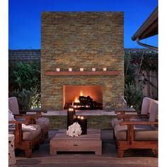 an outdoor fireplace lit up with candles