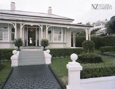 the front entrance to a house with steps leading up to it and bushes on either side