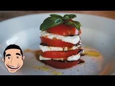 a white plate topped with sliced tomatoes and mozzarella on top of each other