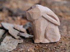 a carved wooden rabbit sitting on the ground