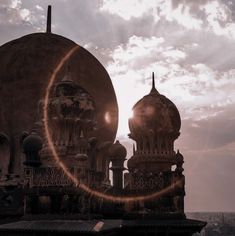 the sun shines brightly behind two domes on top of a building