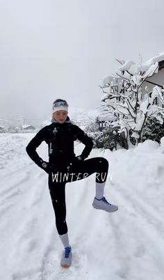 a woman standing in the snow with her hands on her hips