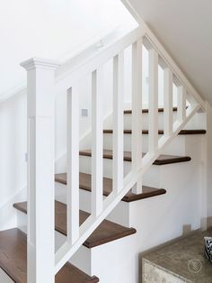 a white staircase with wooden treads in a home