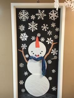 a door decorated with snowmen and decorations for the holiday season in front of a wall