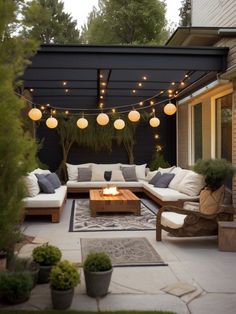 an outdoor living area with couches, tables and lights on the ceiling above it