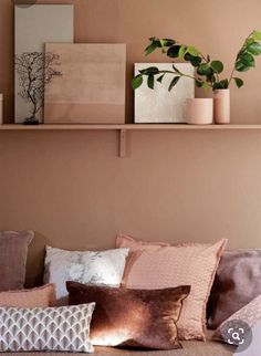 a living room filled with lots of pillows and plants on top of the couches