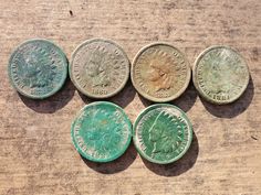 five different types of coins sitting on top of a wooden table