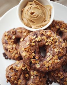 a white plate topped with donuts covered in peanut butter