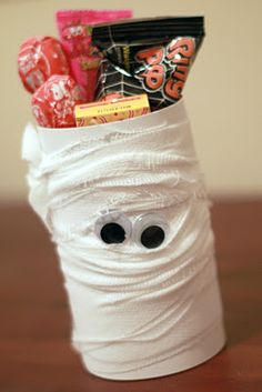 a cup filled with candy and candies on top of a table