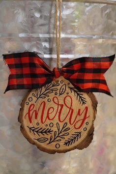 a wooden ornament hanging from a string with the word merry written on it