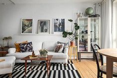 a living room with white couches and black and white rugs on the floor